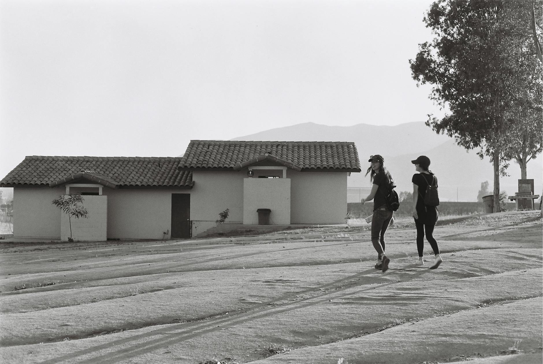 two women walking near house
